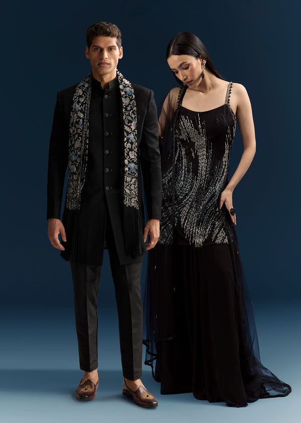 Black Tie Evening Glamour Couple Set – Black Sequins Sharara Suit with Cutdana Embroidery for Her And Black Jacquard Indo-Western Set with Embroidered Stole for Him