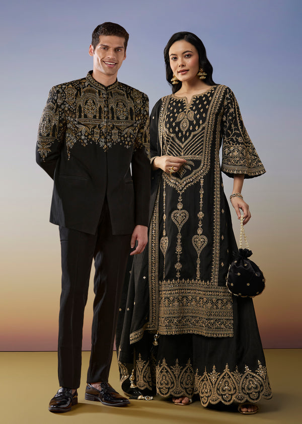 Bold Festive Couple Set – Black Silk Palazzo Suit With Zari Thread And Sequins Work For Her And Black Suiting Jodhpuri Pant Set With Embroidery For Him